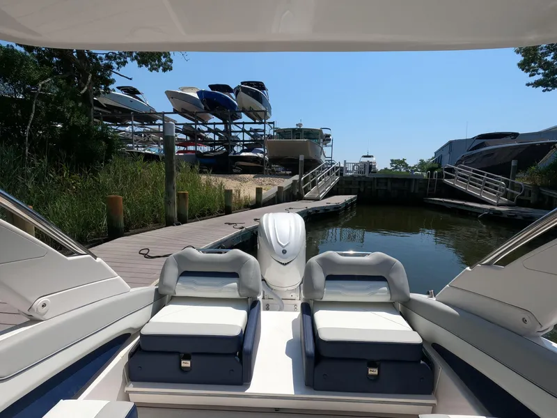 Slide: The Image of 2026 Regal LX6 boat docked at marina with stacked boats in background. - 6