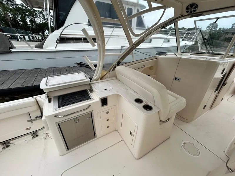 Slide: The Image of 2018 Grady-White Freedom 325 boat interior with seating and kitchenette area. - 2