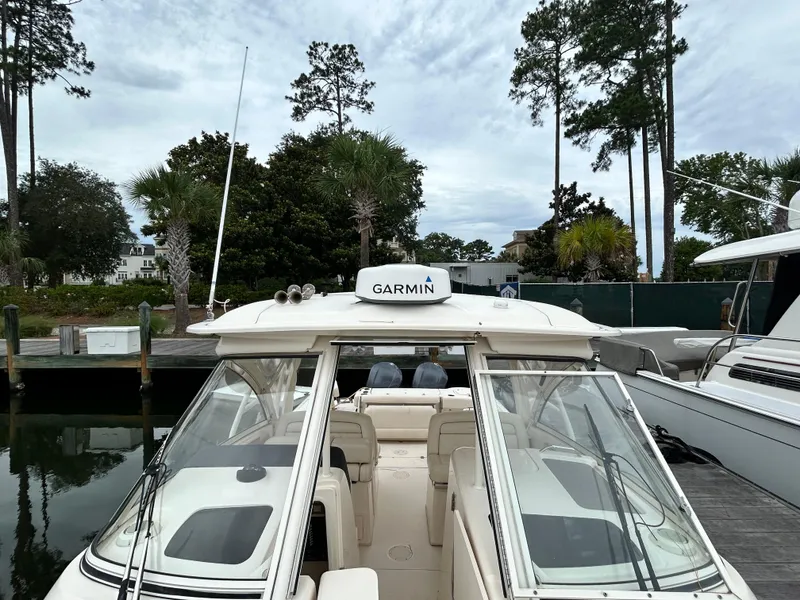 Slide: The Image of 2018 Grady-White Freedom 325 boat docked with Garmin equipment, surrounded by trees. - 7