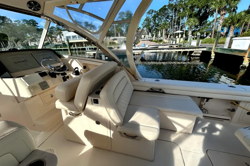 Slide: The Image of 2018 Grady-White Freedom 325 boat interior with helm, seating, and waterfront view. - 9