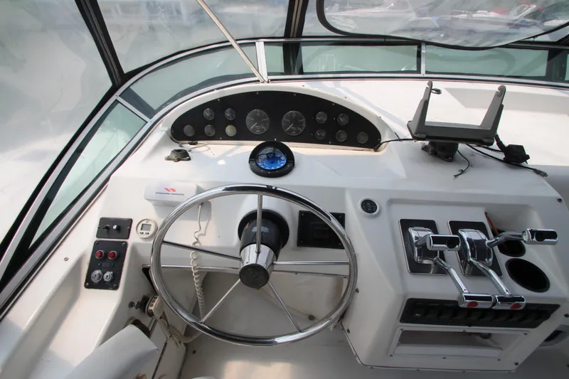 Slide: The Image of 1996 Bayliner 3988 Command Bridge Motoryacht helm with steering wheel and control panel. - 14