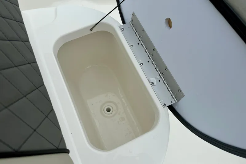 Slide: The Image of Key West 189 FS 2025 boat storage compartment with cushioned seating and open hatch. - 14