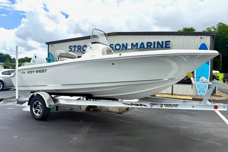 Slide: The Image of 2025 Key West 189 FS boat on trailer at dealership, under cloudy sky. - 4