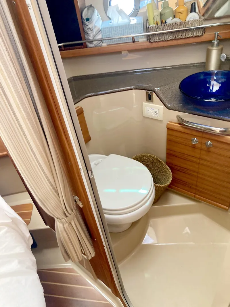 Slide: The Image of 2018 Ranger Tugs R-29 S bathroom with toilet, sink, and wooden cabinetry. - 10