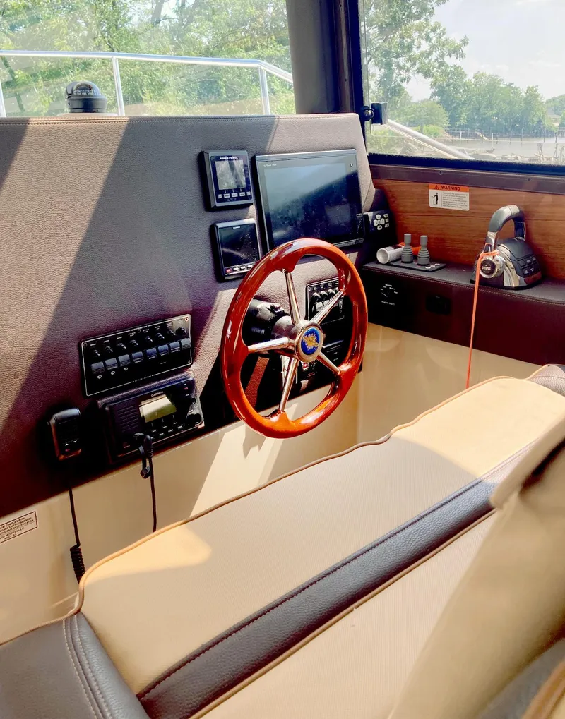 Slide: The Image of Helm of 2018 Ranger Tugs R-29 S with wooden steering wheel and navigation controls. - 9