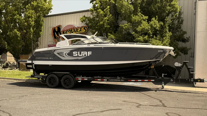 The Image of 2023 Chaparral 28 Surf boat on trailer, parked outdoors near a building. - 0