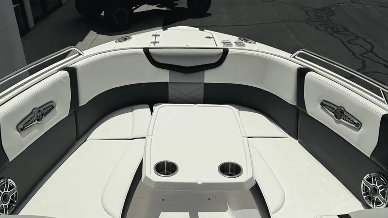 Slide: The Image of 2023 Chaparral 28 Surf boat interior with white and black seating and table. - 10