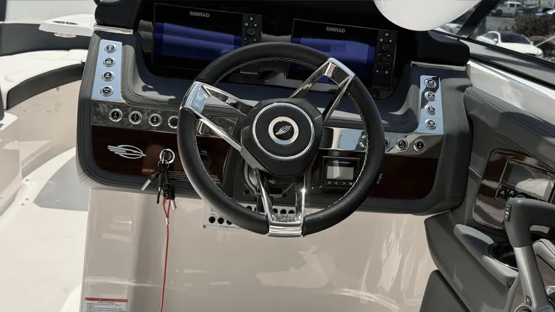 Slide: The Image of 2023 Chaparral 28 Surf boat dashboard with modern steering wheel and controls. - 8