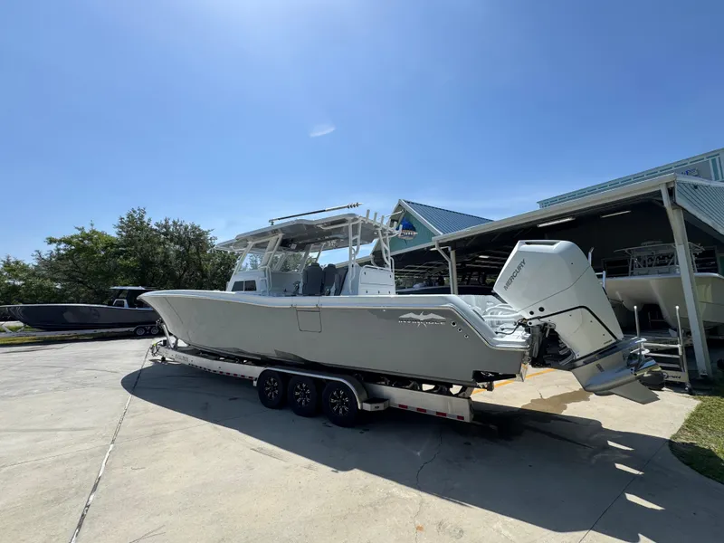 Slide: The Image of 2026 Invincible 43 Open Fisherman boat on trailer under clear blue sky. - 13