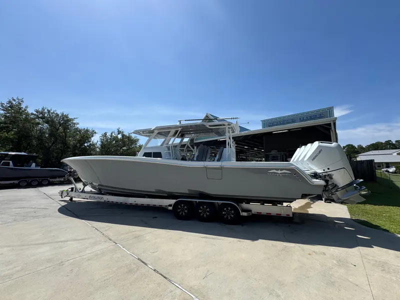 Slide: The Image of 2026 Invincible 43 Open Fisherman boat on trailer, parked outdoors under clear sky. - 14