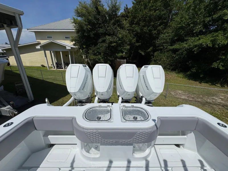 Slide: The Image of 2026 Invincible 43 Open Fisherman with four powerful outboard engines, docked near a house. - 26