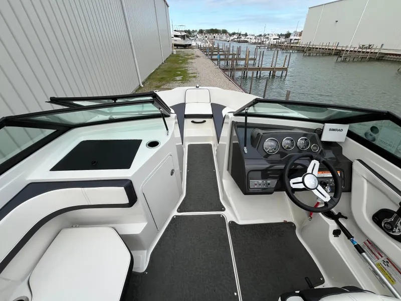 Slide: The Image of 2015 Sea Ray 19 SPX boat interior with steering wheel and dashboard, dockside view. - 13