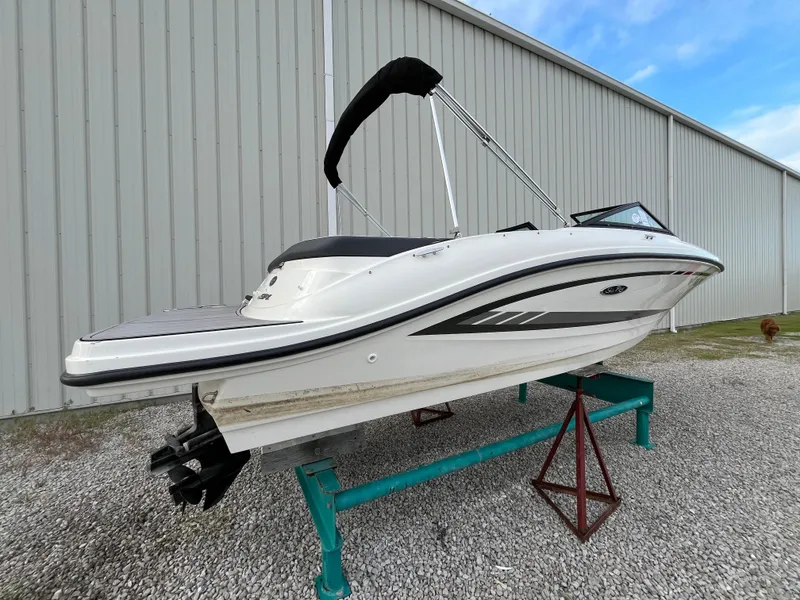 Slide: The Image of 2015 Sea Ray 19 SPX boat on stand, white exterior, near metal building. - 3