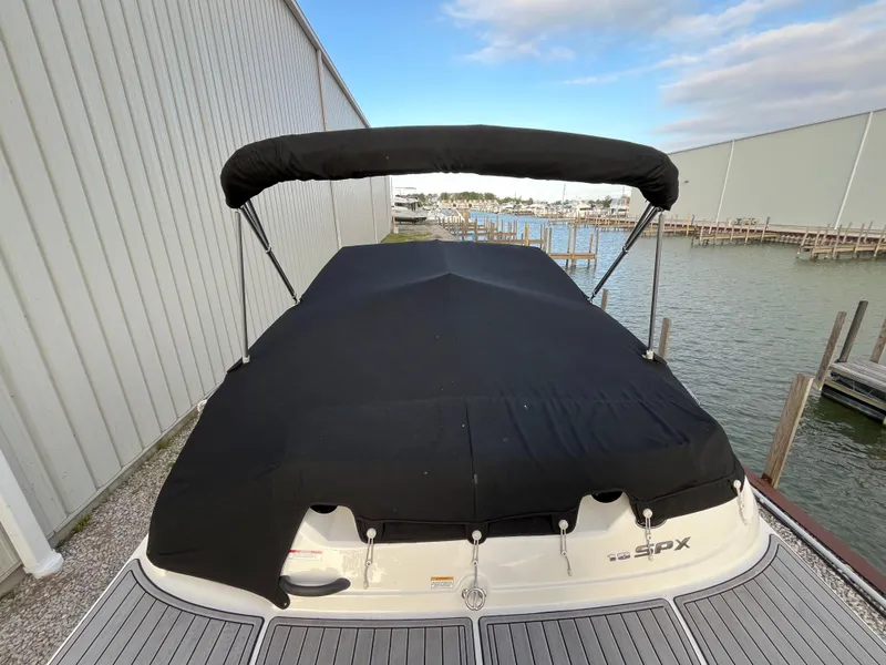 Slide: The Image of Covered 2015 Sea Ray 19 SPX boat docked by a marina, featuring a black canopy. - 4