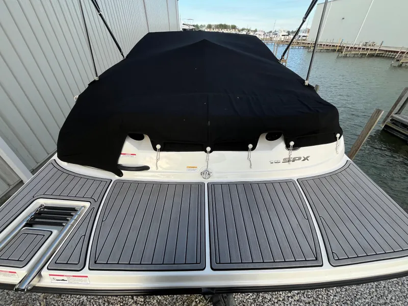 Slide: The Image of 2015 Sea Ray 19 SPX boat with black cover docked by the water. - 5
