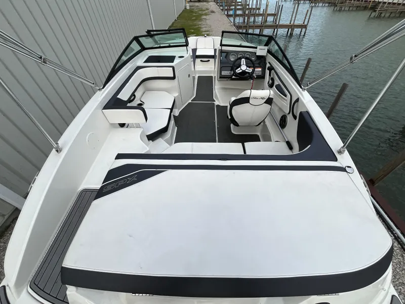 Slide: The Image of 2015 Sea Ray 19 SPX boat interior with seating and steering wheel, docked by the water. - 8