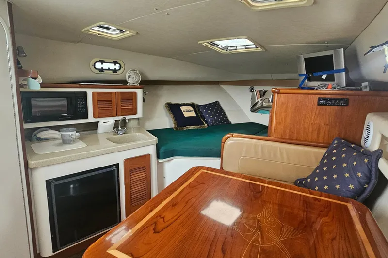 Slide: The Image of 2000 Pursuit 3000 Express cabin interior with kitchenette, bed, and seating area. - 10