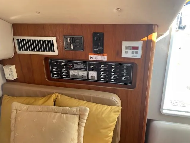 Slide: The Image of Control panel inside 2000 Pursuit 3000 Express boat cabin with wood finish and cushions. - 12