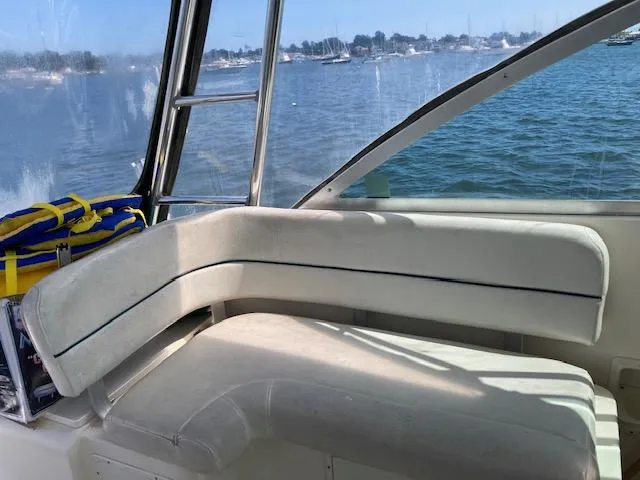 Slide: The Image of Interior view of a 2000 Pursuit 3000 Express boat with white seating and ocean backdrop. - 6