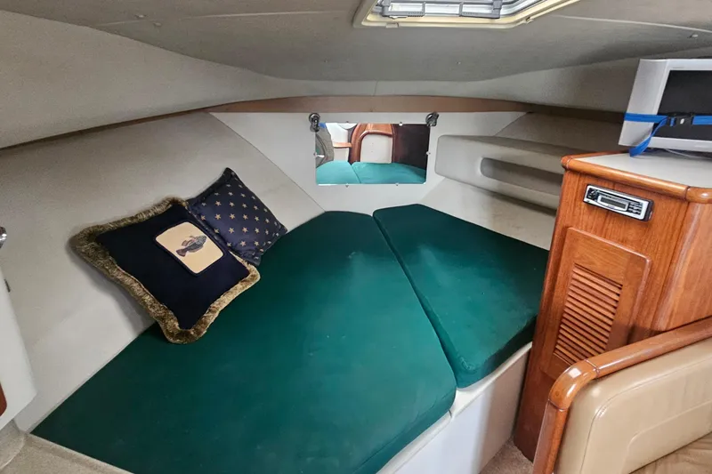 Slide: The Image of 2000 Pursuit 3000 Express cabin interior with green cushions and wooden cabinetry. - 7