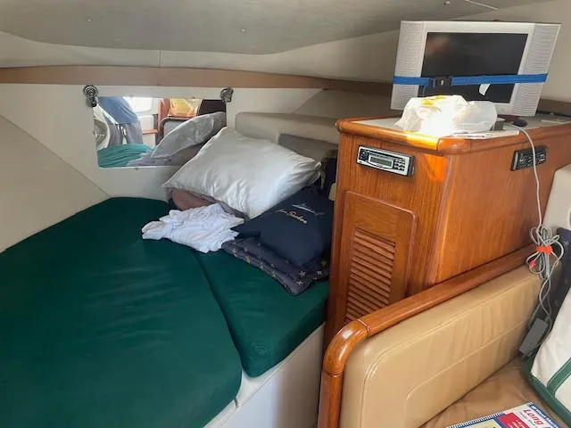 Slide: The Image of Cozy cabin interior of 2000 Pursuit 3000 Express boat with green bedding and wooden cabinetry. - 8