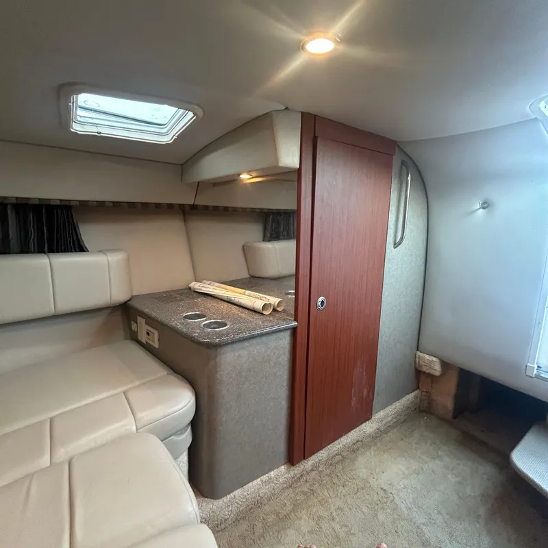 Slide: The Image of Interior of 2005 Formula 330 SS boat, featuring seating, wood paneling, and overhead lighting. - 13