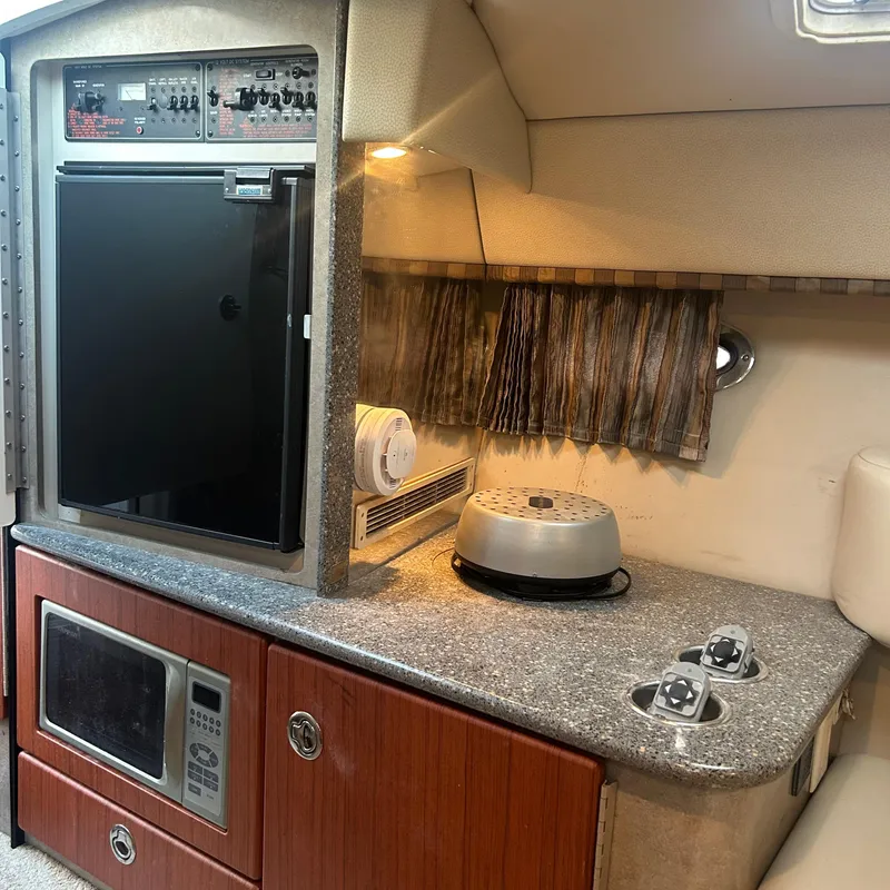 Slide: The Image of 2005 Formula 330 SS cabin interior with kitchenette, featuring microwave and compact fridge. - 15