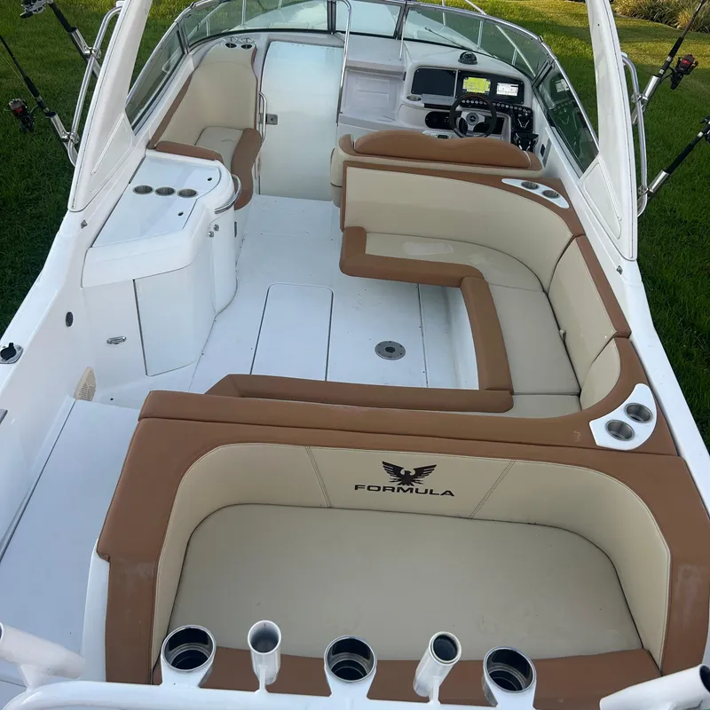 Slide: The Image of 2005 Formula 330 SS boat interior with tan and white seating, steering console, and rod holders. - 17
