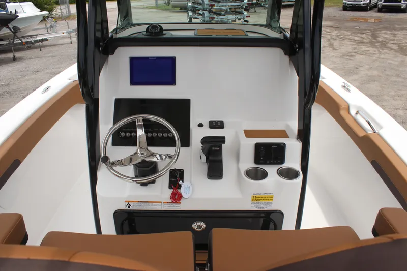 Slide: The Image of 2024 Sea Pro 242 Center Console boat dashboard with steering wheel and controls. - 21