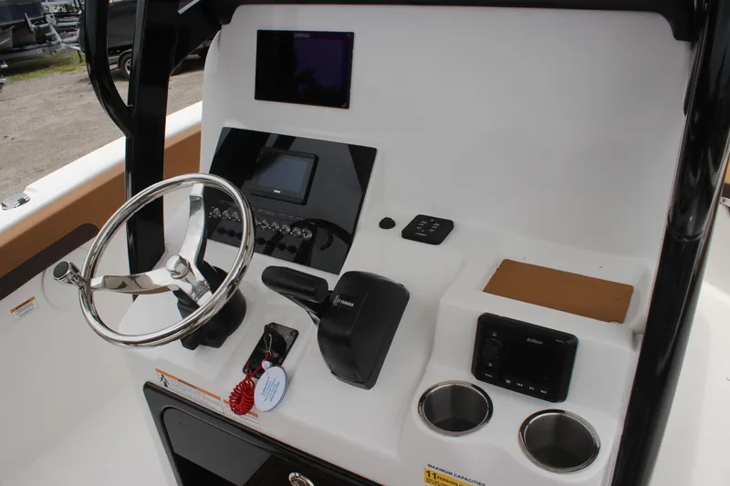 Slide: The Image of 2024 Sea Pro 242 Center Console boat dashboard with steering wheel and controls. - 22
