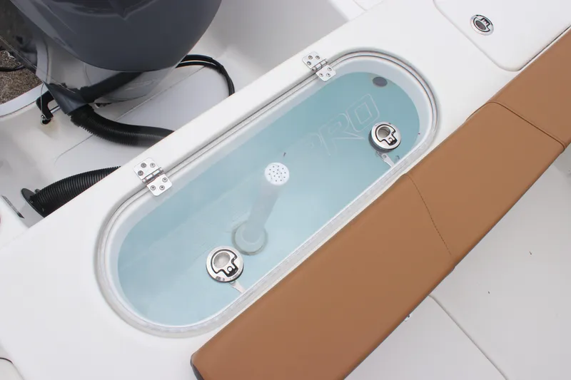 Slide: The Image of 2024 Sea Pro 242 Center Console livewell with brown seating and engine components. - 25