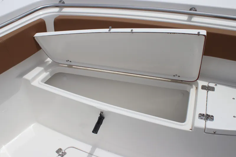 Slide: The Image of 2024 Sea Pro 242 Center Console storage compartment with open lid, showcasing spacious interior. - 36