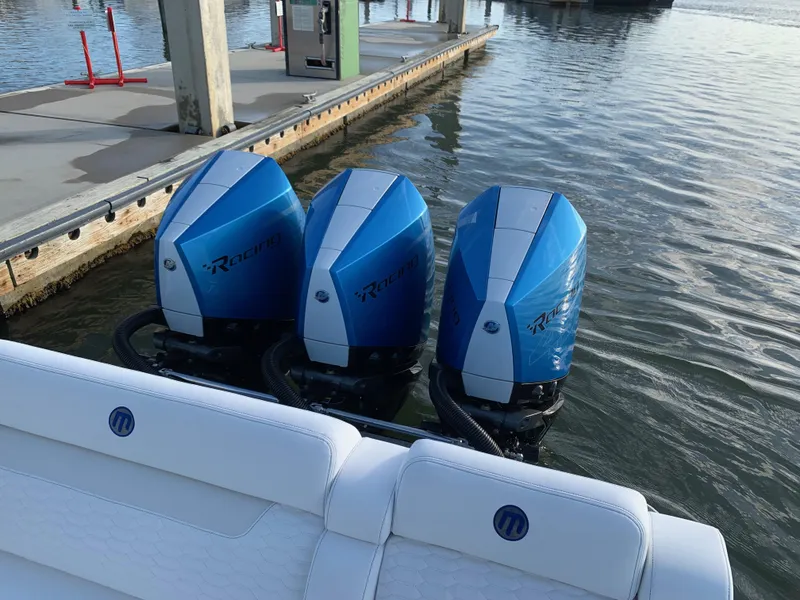 Slide: The Image of 2023 Mystic Powerboats M3800 with triple blue outboard engines docked at marina. - 12