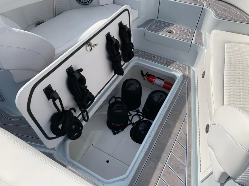 Slide: The Image of Storage compartment in 2023 Mystic Powerboats M3800, featuring ropes and a fire extinguisher. - 17