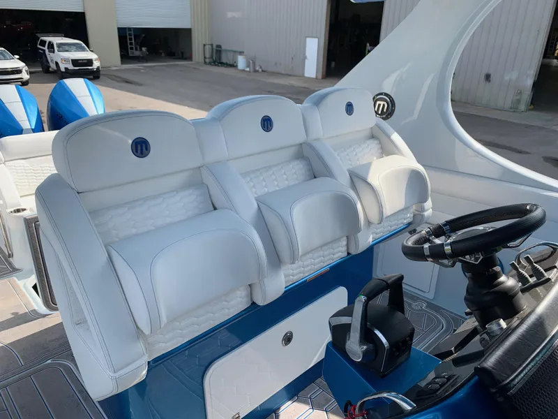 Slide: The Image of 2023 Mystic Powerboats M3800 cockpit with white seating and modern controls. - 18