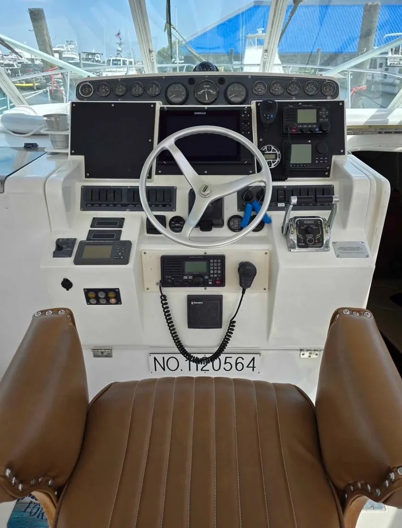 Slide: The Image of Cockpit of 2000 Rampage 38 Express boat with steering wheel and navigation instruments. - 4