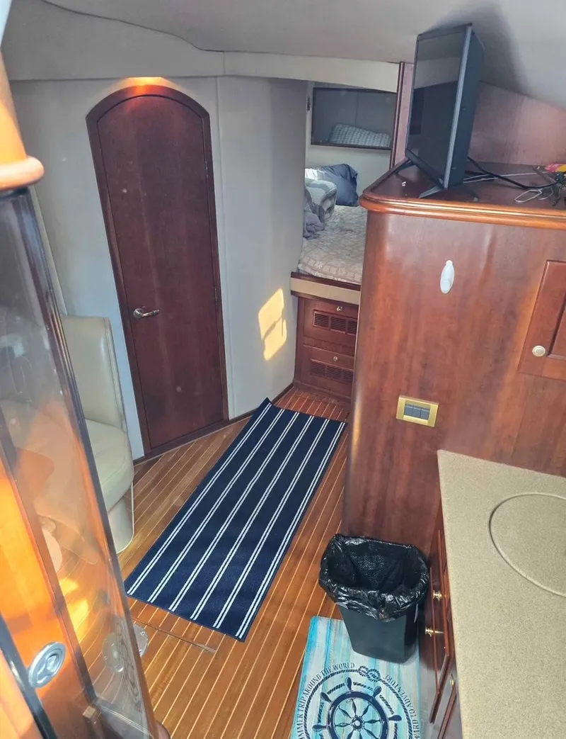 Slide: The Image of Interior of 2000 Rampage 38 Express boat with wood finish and striped rug. - 5