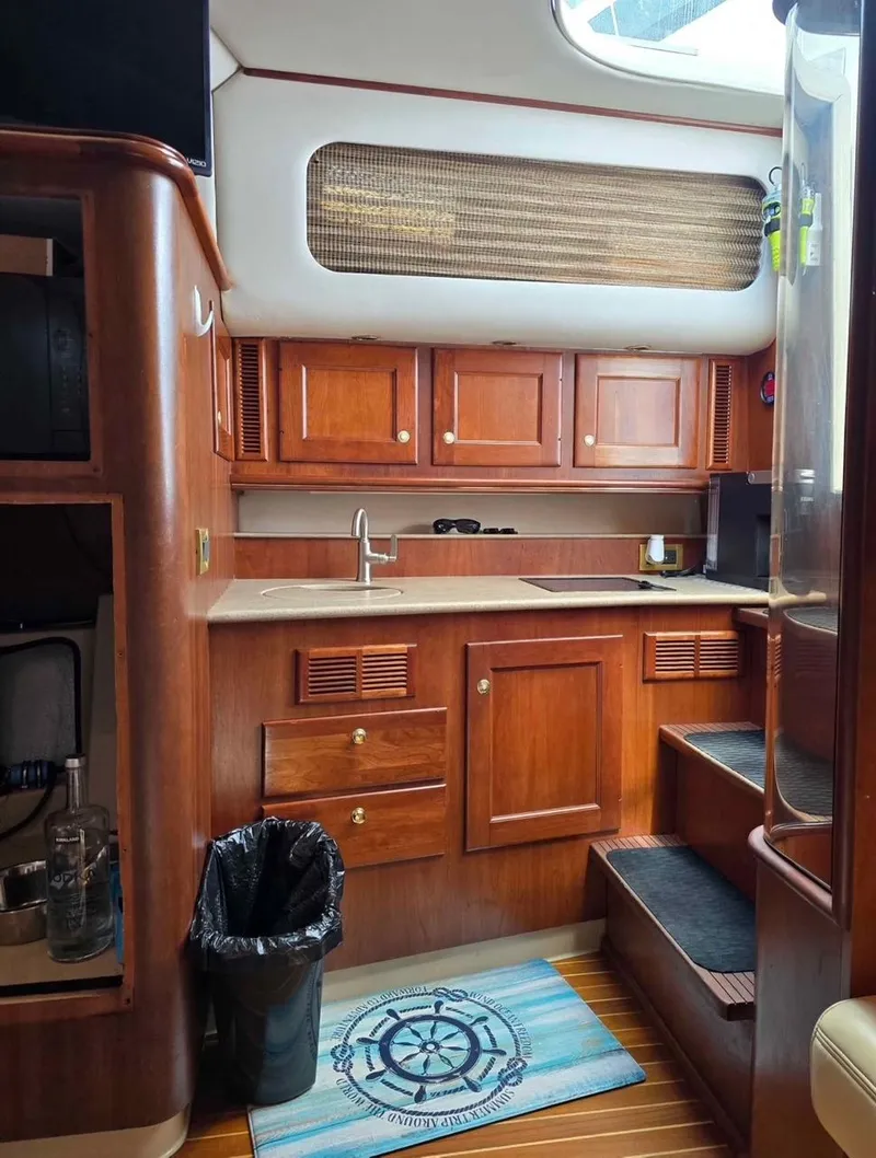 Slide: The Image of Interior of a 2000 Rampage 38 Express yacht with wooden cabinetry and compact kitchen area. - 7