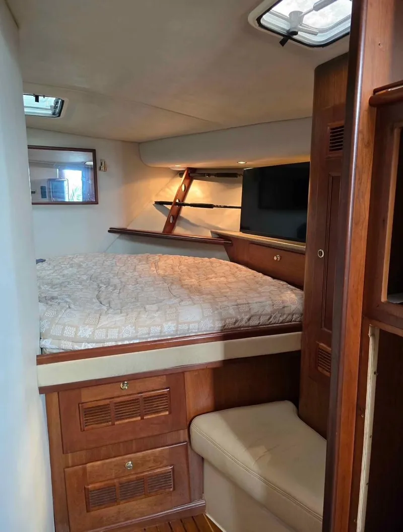 Slide: The Image of 2000 Rampage 38 Express cabin interior with bed, wooden cabinetry, and seating. - 8
