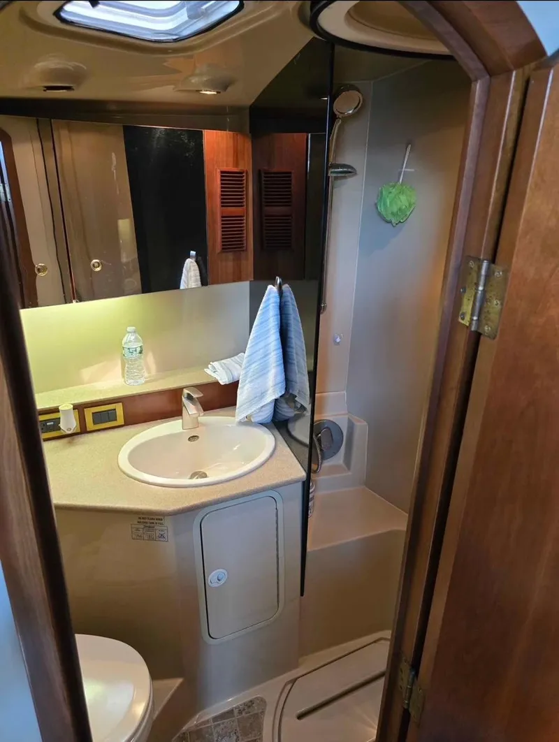 Slide: The Image of 2000 Rampage 38 Express boat bathroom with sink, mirror, and shower area. - 9