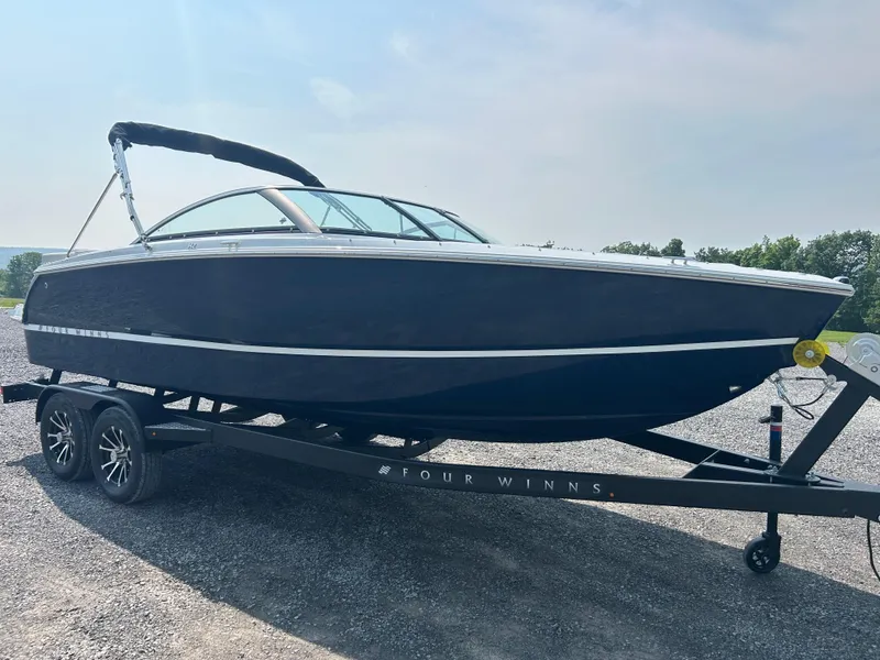 The Image of 2026 Four Winns H2 Freedom boat on trailer, sleek design, parked outdoors. - 1