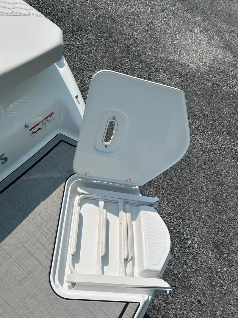 Slide: The Image of 2026 Four Winns H2 Freedom boat storage compartment with open lid on deck. - 20