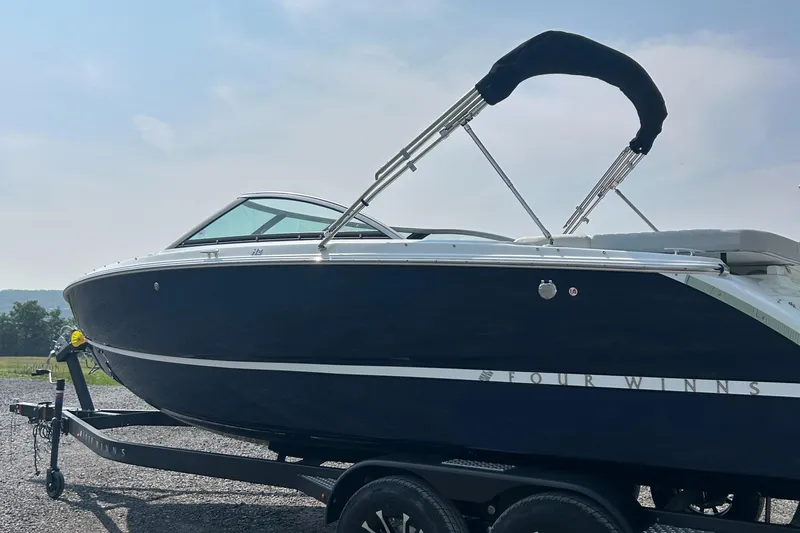 Slide: The Image of 2026 Four Winns H2 Freedom boat on trailer, sleek design, black hull, sunny day. - 3