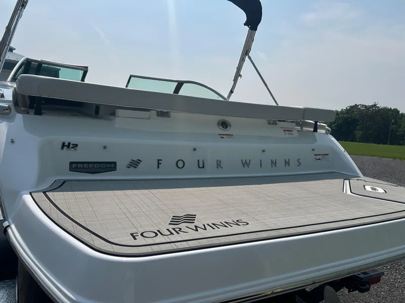 Slide: The Image of 2026 Four Winns H2 Freedom boat, rear view with branding and swim platform. - 4