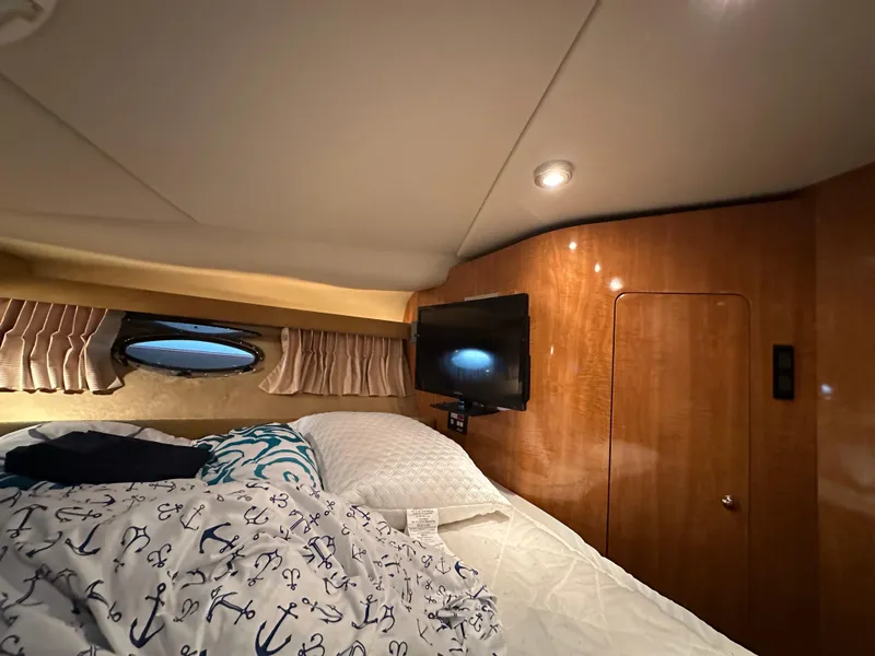 Slide: The Image of Cozy cabin interior of 2004 Regal Commodore 3860 with bed, TV, and porthole window. - 18
