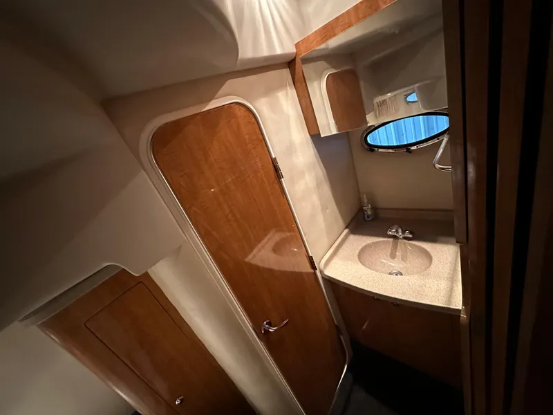 Slide: The Image of 2004 Regal Commodore 3860 yacht bathroom with wood accents and round mirror. - 22