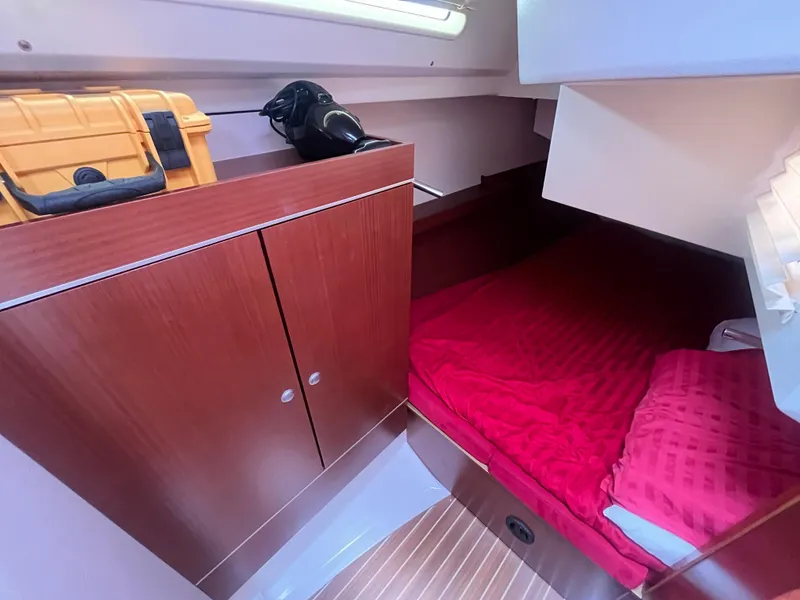 Slide: The Image of Cozy cabin interior of 2014 Hanse 345 yacht with red bedding and wooden cabinetry. - 22