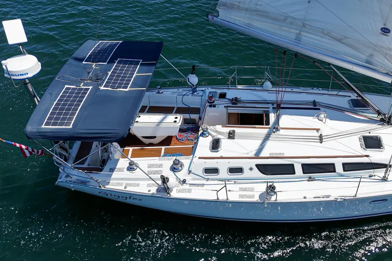 Slide: The Image of 2002 Jeanneau Sun Odyssey 43 sailboat with solar panels on deck, cruising on water. - 11