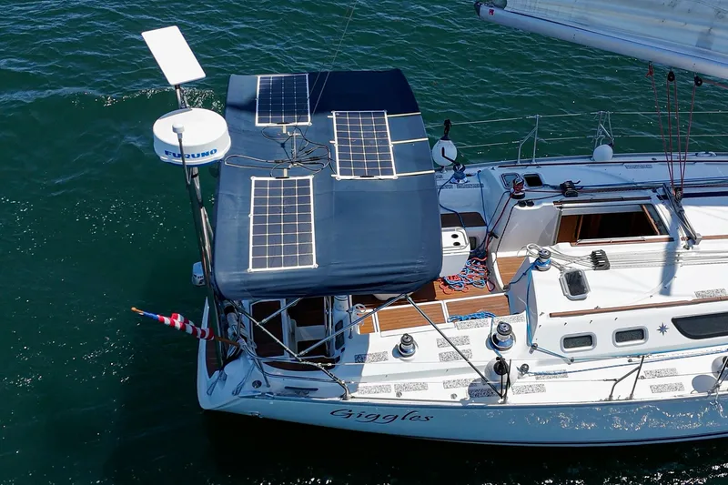 Slide: The Image of Jeanneau Sun Odyssey 43 sailboat with solar panels, 2002 model, on the water. - 12