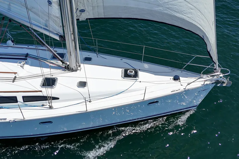 Slide: The Image of Jeanneau Sun Odyssey 43 sailboat from 2002 gliding on the water with sails unfurled. - 13